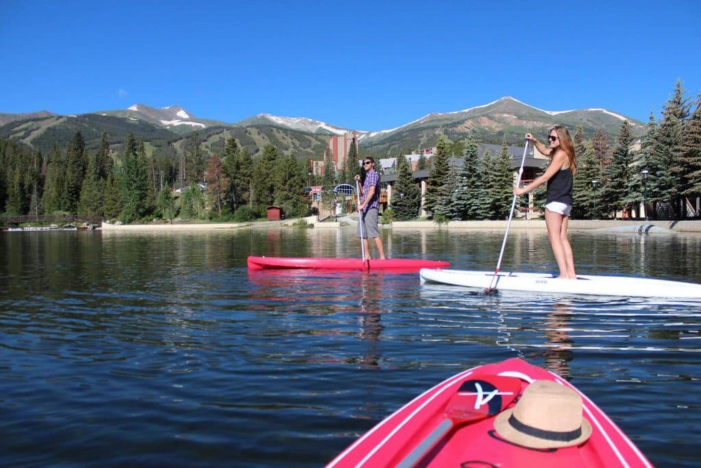 Two paddleboarders on Maggie Pond in Breckenridge during Summer.