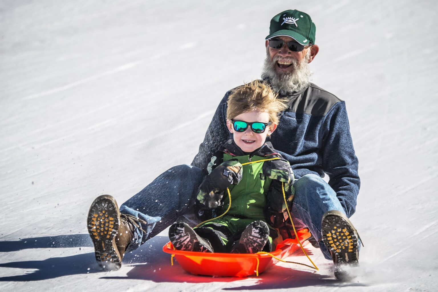 Grandfather and grandson sledding in Breckenridge