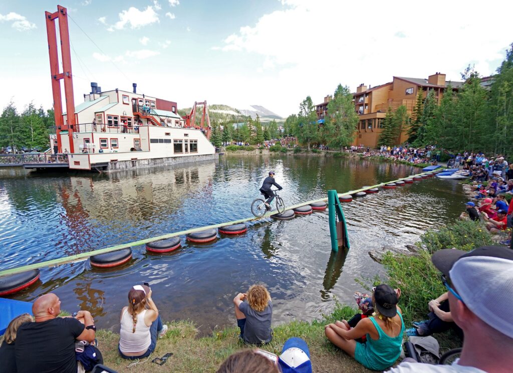 Person riding bike over a lake with obstacles