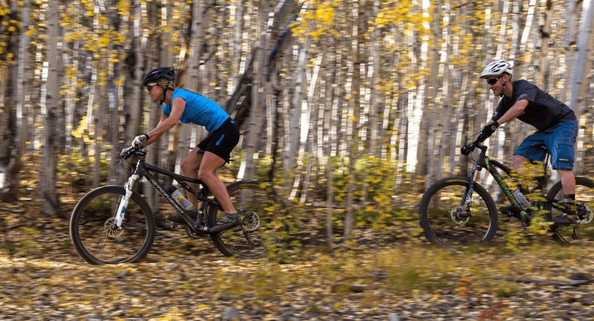 Couple Mountain Biking Through the Woods in Breckenridge