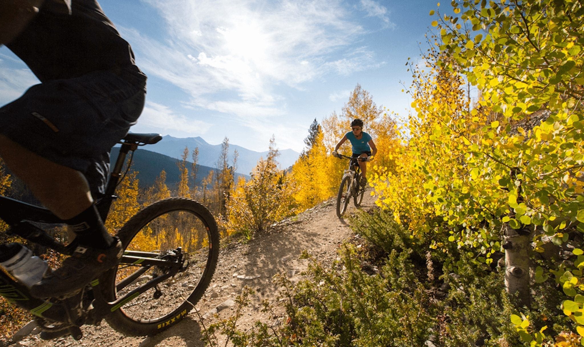 Couple Mountain Biking through Fall Trees