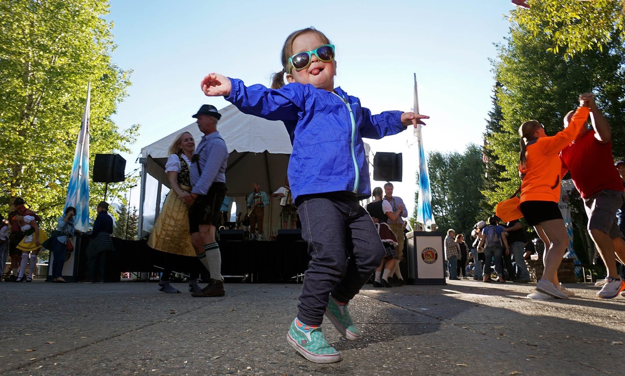 A young girl wearing sunglasses and dancing