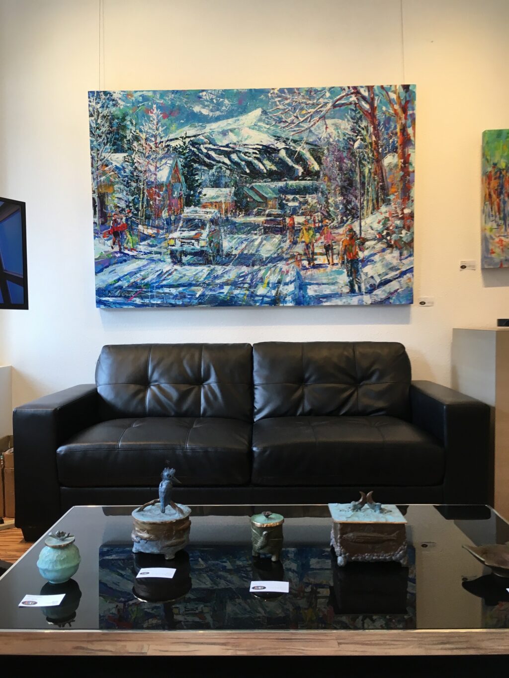 snowy painting above a leather couch