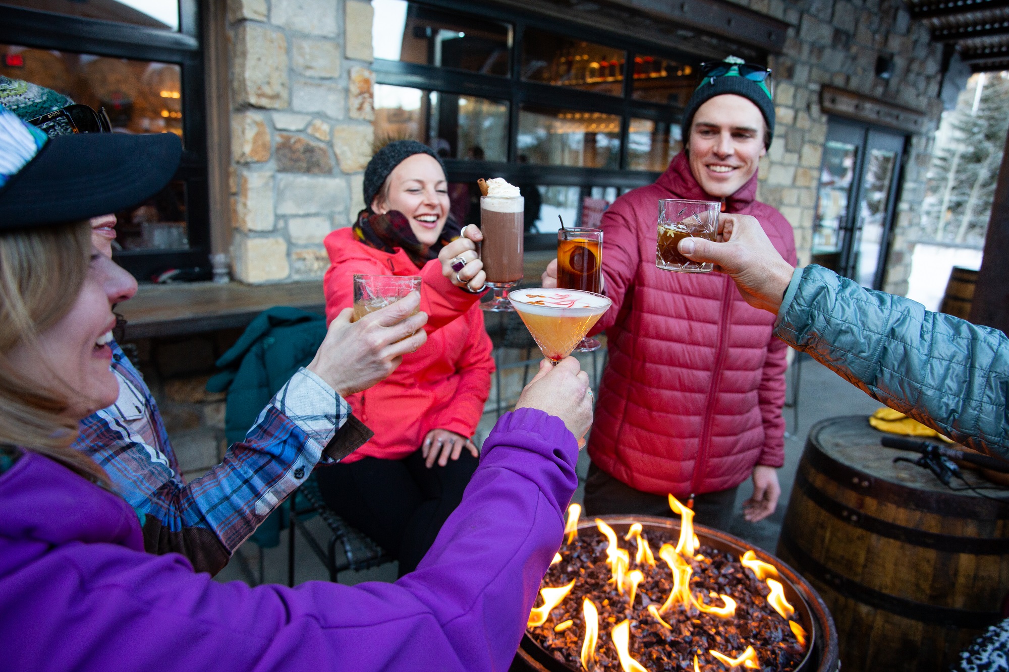 group enjoying some drinks around a fire