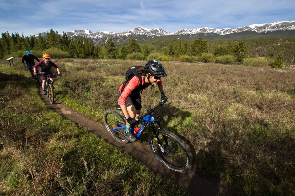 three people biking on a mountain trail