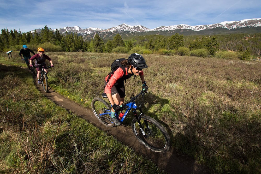 three people biking on a mountain trail