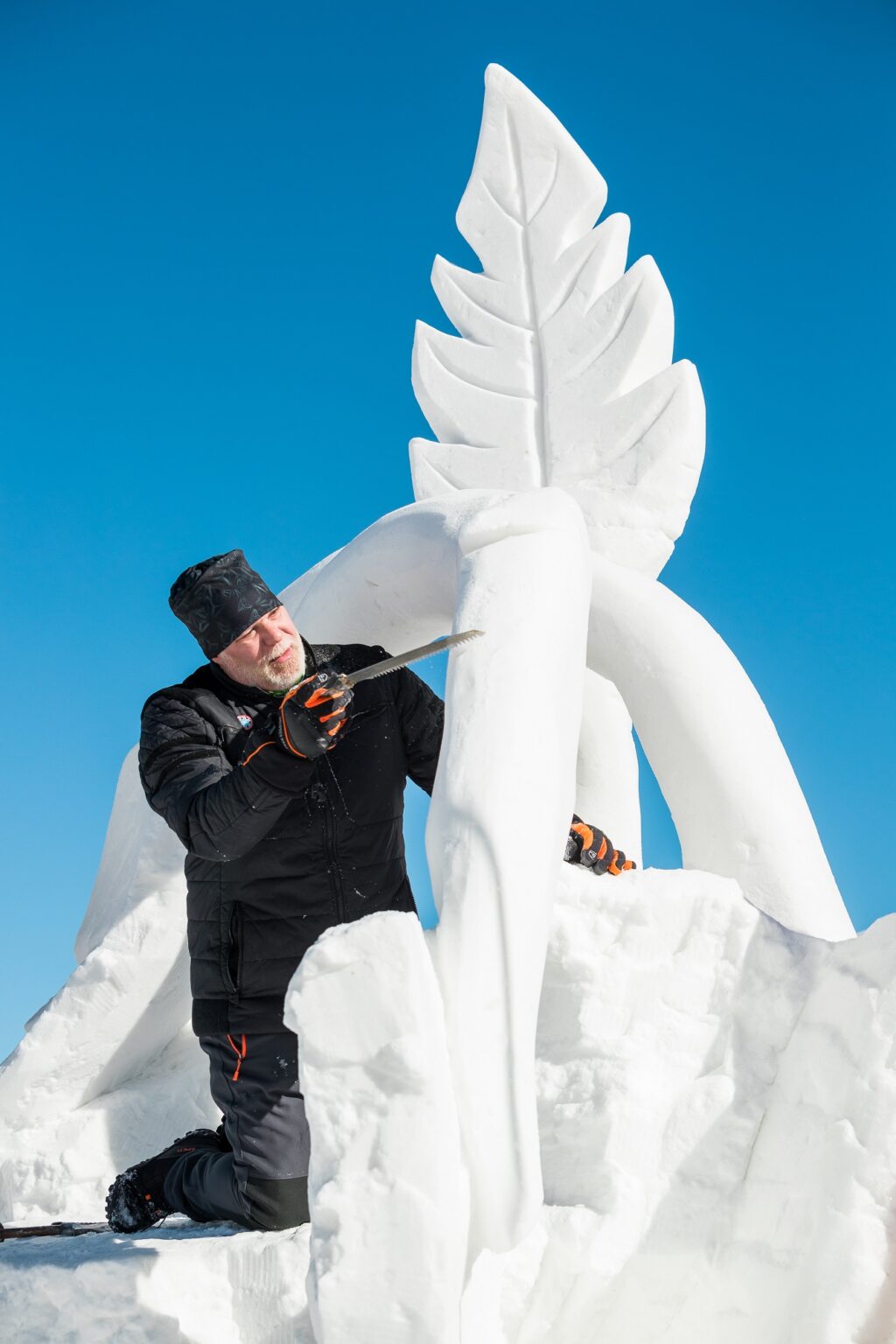 man working on an ornate snow sculpture