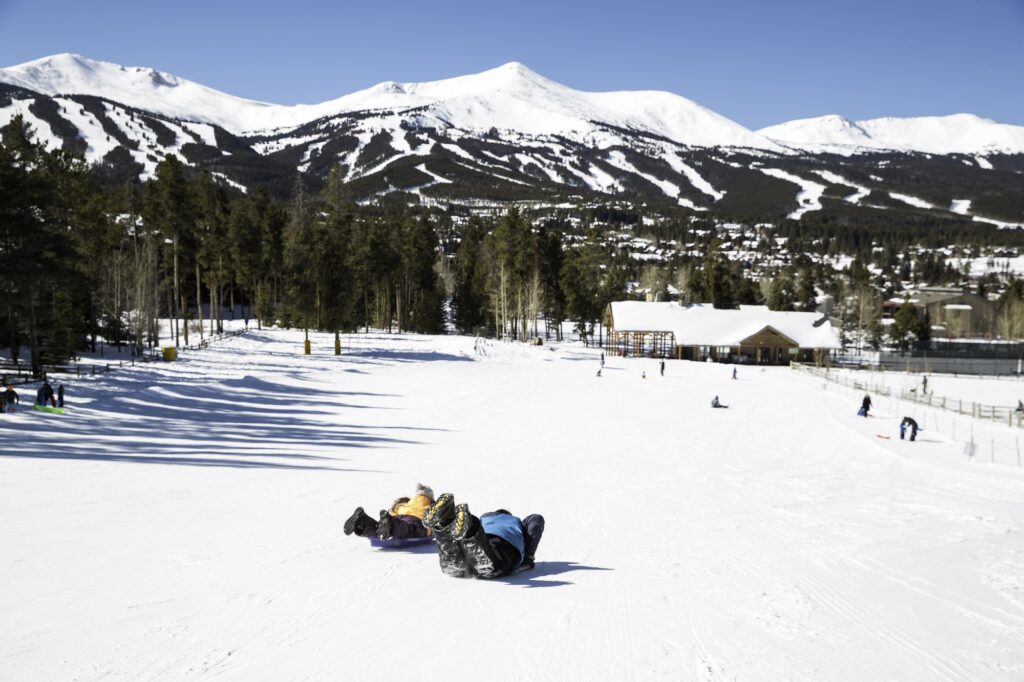Kids sliding down a snowy slope