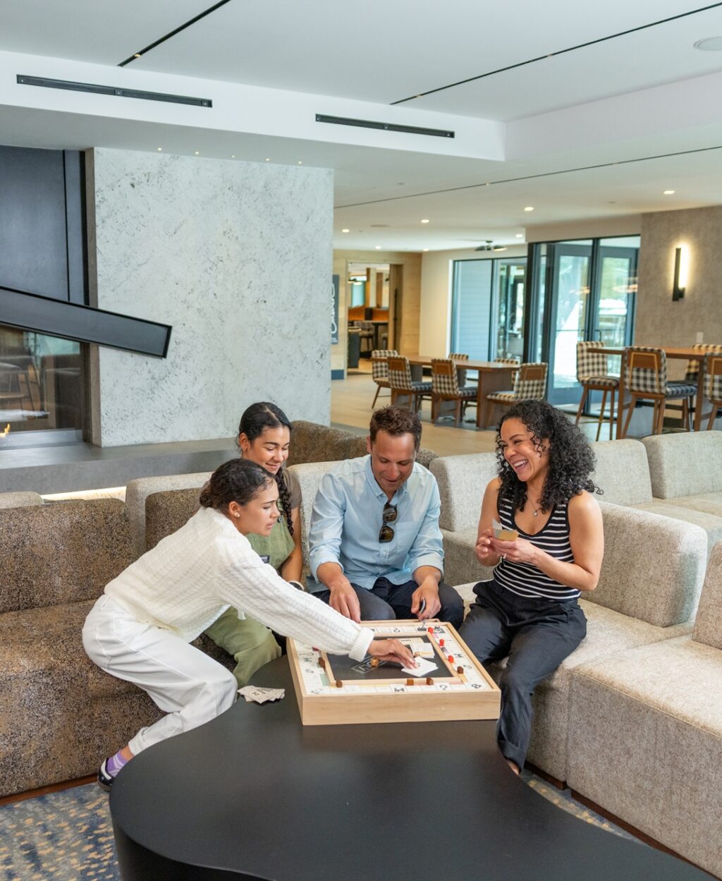 group of people playing a boardgame in a lobby