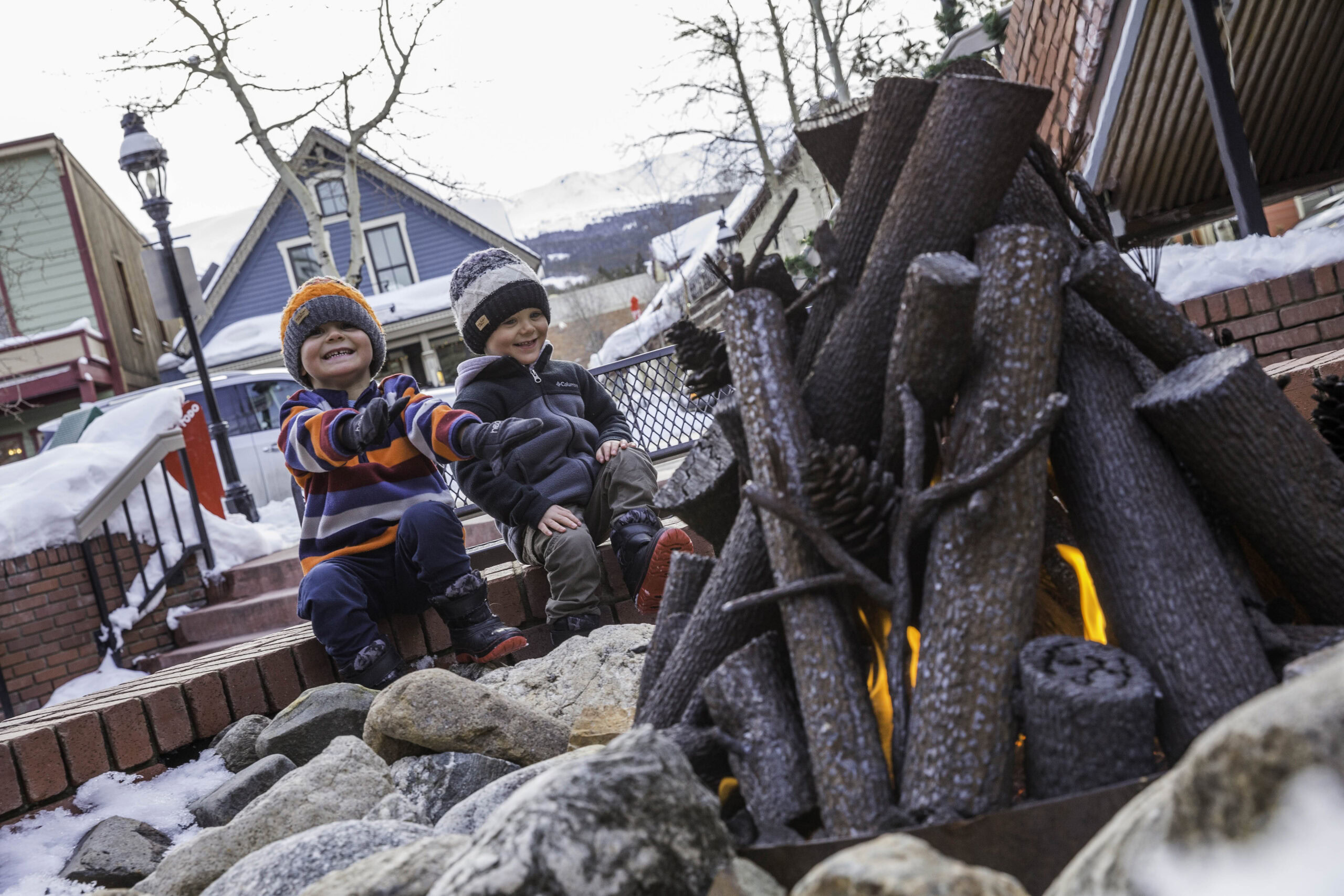 two young children warm their hands by a firepit in downtown Breckenridge